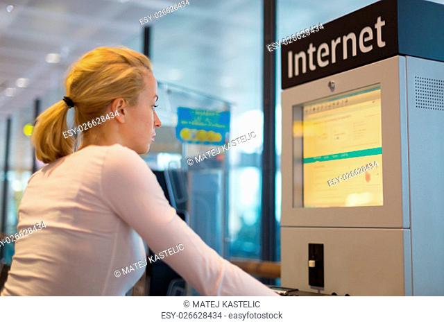 Young caucasian woman using comupter with public internet access point on airport