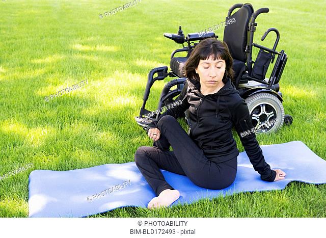 Disabled woman stretching legs in park