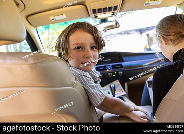 Young boy looking at camera in parked car