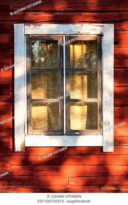 Old window in red wooden house