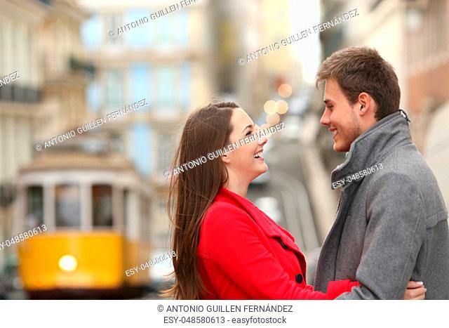 Cheerful couple looking each other in the street