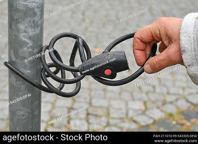 21 September 2021, Brandenburg, Prenzlau: Eva Becker, archaeologist, shows an old bicycle lock connected to a pole. ""What a society throws away reveals a lot...