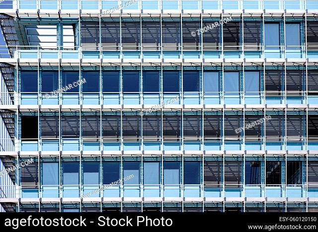 Die moderne Fassade eines Bürohauses mit Fensterreihen und Metalljalousien