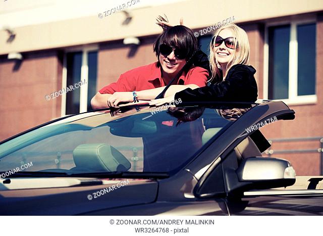 Happy young couple at the convertible car