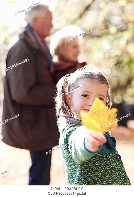 Girl holding out autumn leaf