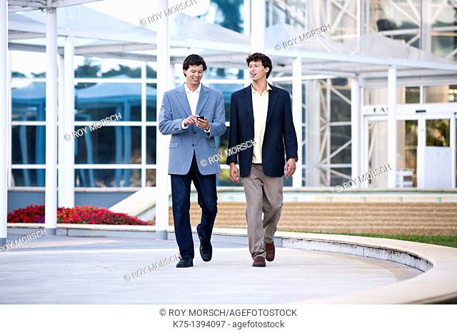 Twin brothers walking outside modern office building