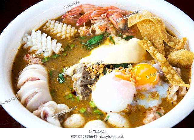 Special noodle spicy soup or noodles tom yam soup thai style with pork and seafood and soft-boiled egg and other seasoning
