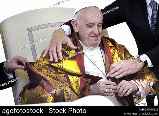 An Indian priest covers the shoulders of Pope Francis with a yellow shawl, a symbol of respect and honor..Pope Francis during a weekly general audience at Saint...