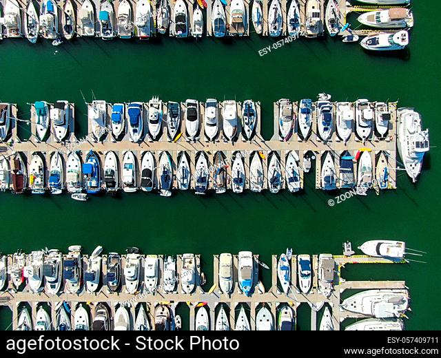 Aerial top view of boats and yachts in marina. Marina lot with yachts, sailboat and speedboat moored at the quay