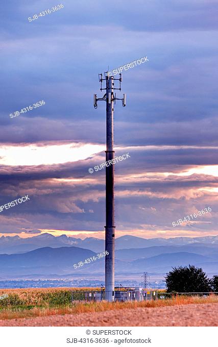 Cellular telephony signal relay tower at dusk, Rocky Mountains in distance, Colorado. High dynamic range, or HDR image