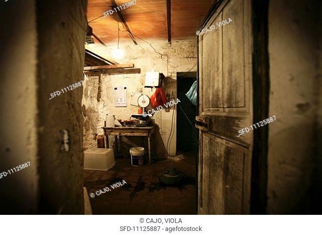 A view into a windowless room with a wooden table a pair of scales