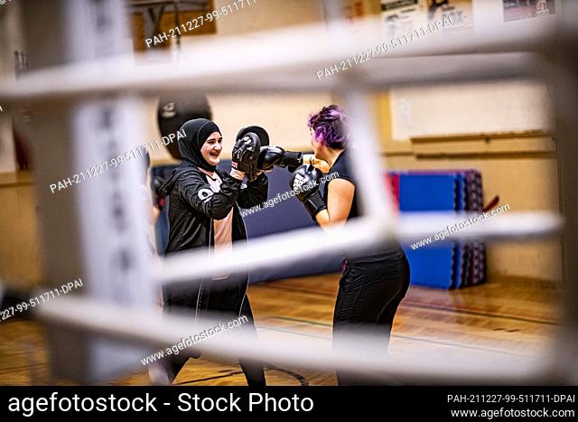 16 December 2021, Berlin: Boxing coach Doha Taha Beydoun trains with one of her boxers. She's only 20. Married. Four months pregnant