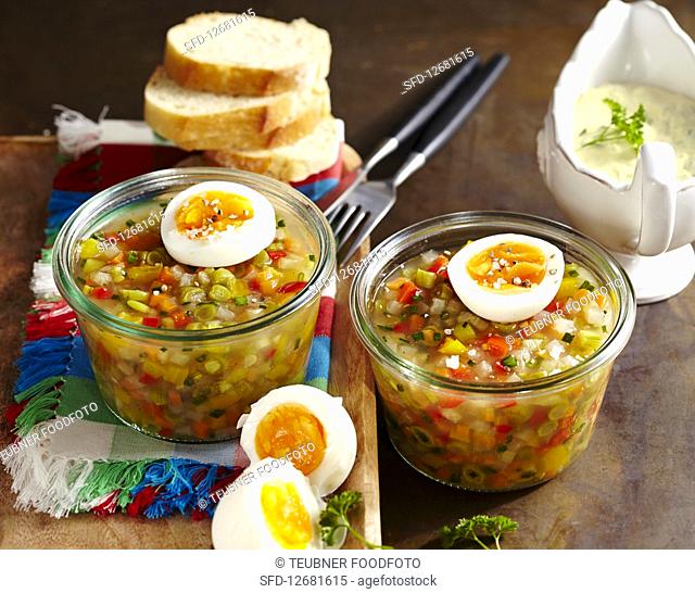 Vegetarian vegetable jelly with agar agar, boiled egg, baguette slices and chive sauce
