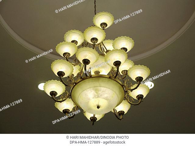 Chandelier with multiple lamps hanging from ceiling