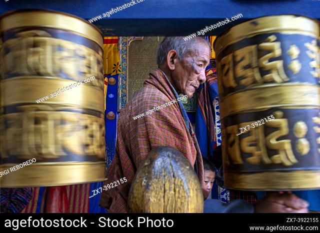 Spinning prayer wheel at Kyichu Lhakhang Temple near Paro in Himalayas mountains Bhutan, South Asia, Asia. Inner courtyard with an incense burner and orange...