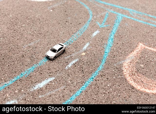 toy car on a asphalt. chalk painted road markings. right-hand movement, rotation and strip