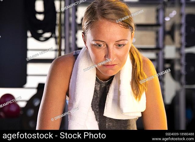 Portrait of a young woman resting in gym after a hard workout