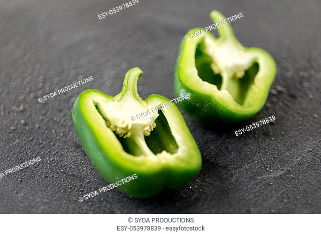 cut green pepper on slate stone background