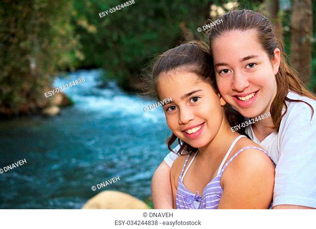 Beautiful teenage sisters relaxing on the Jordan River