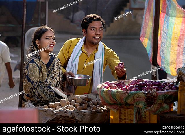 A HAPPY RURAL HUSBAND AND WIFE BUYING VEGETABLES