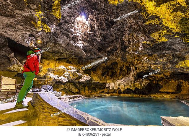 Young woman in a cave with a geothermal spring, Cave and Basin National Historic Site, Banff National Park, Alberta, Canada, North America