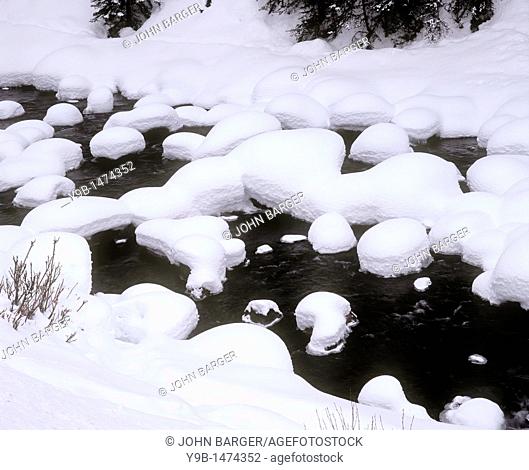 Winter snow covers rocks and banks of Soda Butte Creek, Yellowstone National Park, Wyoming, USA