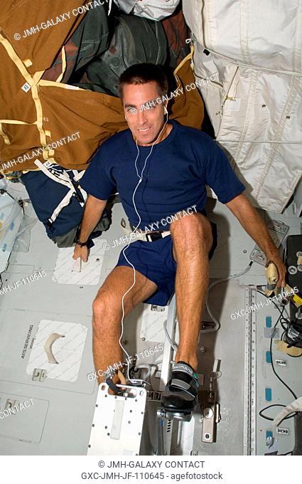 Astronaut Christopher Cassidy, STS-127 mission specialist, exercises on a bicycle ergometer on the middeck of the Earth-orbiting Space Shuttle Endeavour