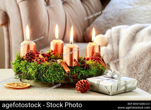 Advent wreath made of moss, cinnamon sticks and rosa canina twigs. Festive decor