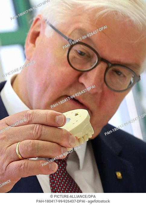 17 April 2018, Berlin, Germany: German President Frank-Walter Steinmeier looks at artifically produced teeth at the Education and Technology Centre (BTZ) during...