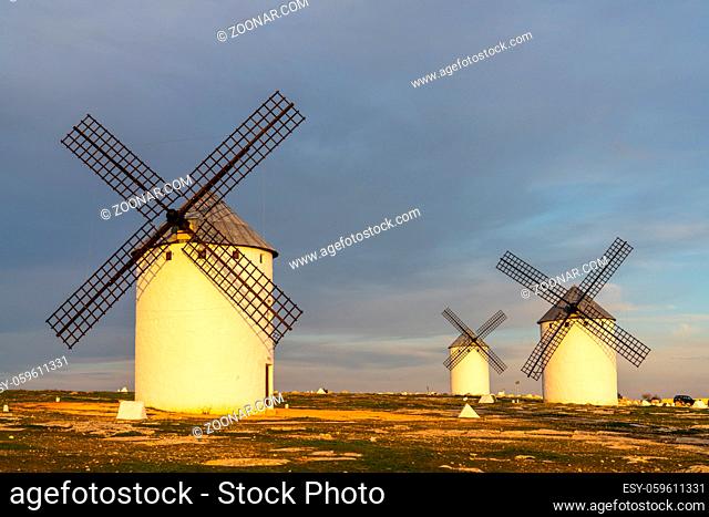 A view of the historic white windmills of La Mancha above the town of Campo de Criptana in warm evening light