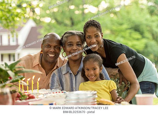 Portrait of smiling multi-generation family celebrating with cake