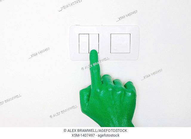 A green hand switching on a light