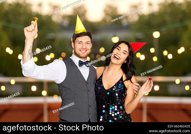 happy couple with party blowers having fun