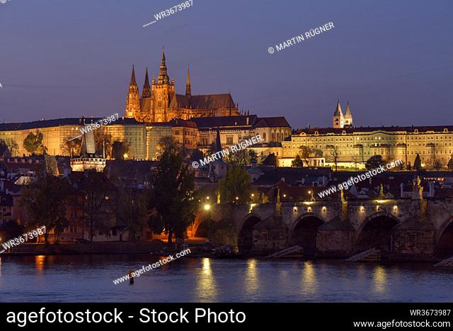 Czech Republic, Prague, Charles Bridge stretching over Vltava river at dusk with Prague Castle looming in background