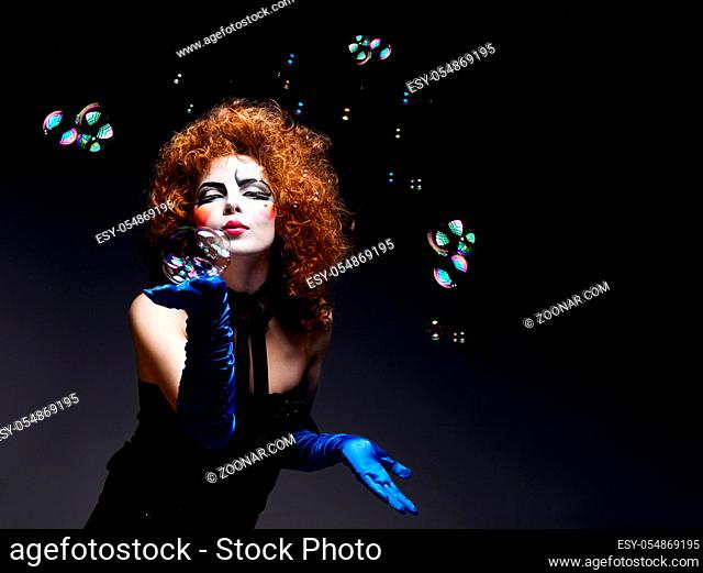 Woman mime with theatrical makeup and soap bubbles. Studio shot