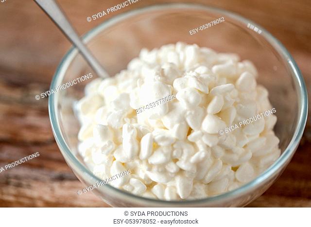 close up of cottage cheese in bowl on wooden table
