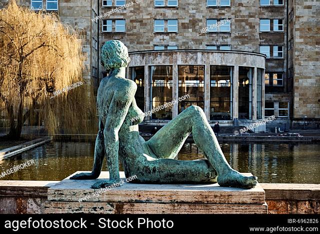 On the waterfront, sculpture of a woman, nude in bronze by Fritz Klimsch, behind the back of the main building of the university