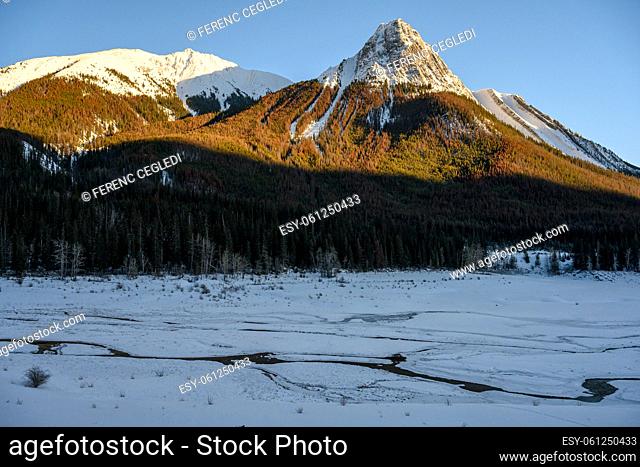 Winter landscape of the frozen Lake Medicine surrounded by the Colin Range, which is a part of the Canadian Rocky Mountains in Jasper National Park, Alberta