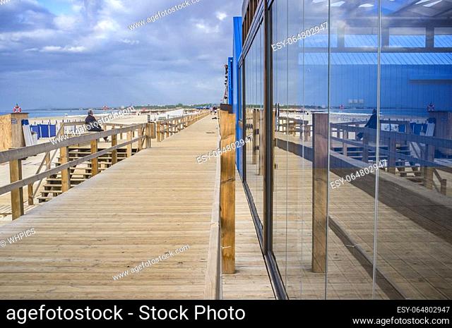 Restaurant glass and wooden footbridge beside the beach. Monte Gordo beach, Vila Real de Santo Antonio, Portugal