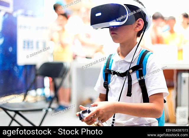little chinese boy plays game with VR in ST exhibition