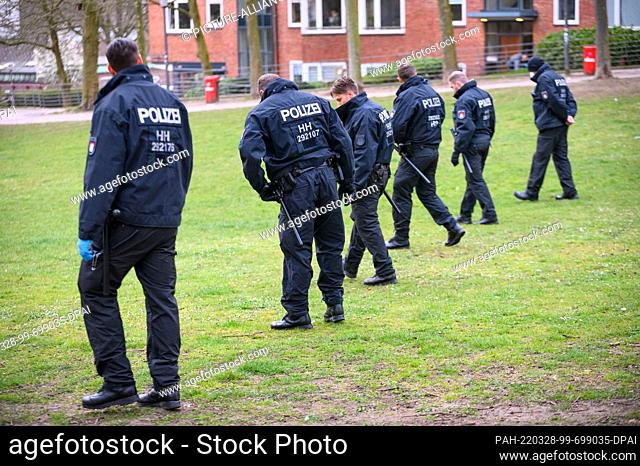 28 March 2022, Hamburg: Riot police search the widely cordoned off Michelwiese in front of the main church of St. Michaelis for traces