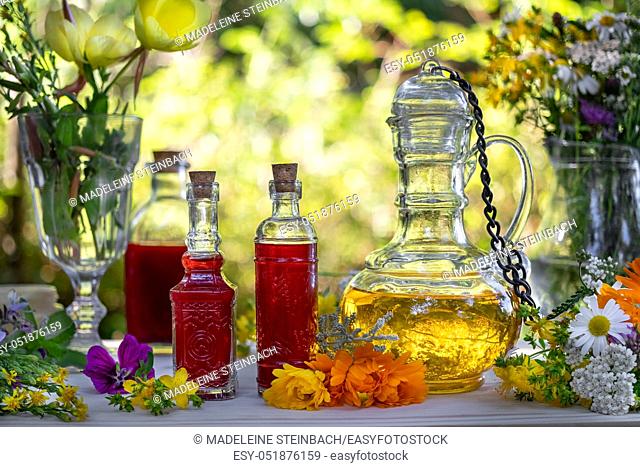 Bottles of St. John's wort and evening primrose oil with a mix of fresh medicinal herbs, outdoors