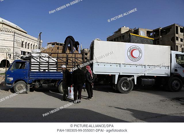 Volunteers unload aid material delivered to the rebel-held city of Douma, Eastern Ghouta province, Syria, 05 March 2018. A 46-truck convoy includes UN agencies
