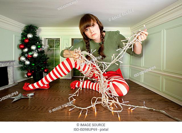Young woman in small room with christmas lights