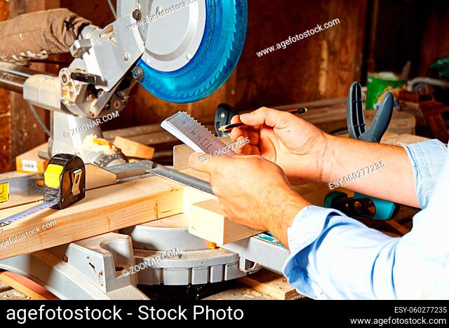 Carpenter work concept. Carpenter work with circular saw for cutting wood bar, the man sawed bars, construction and home renovation