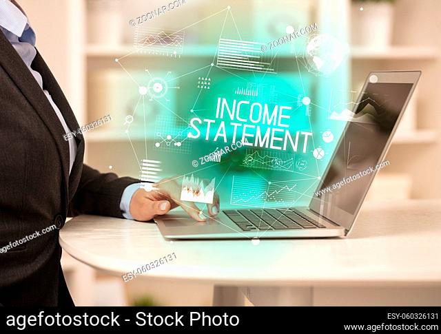Side view of a business person working on laptop with INCOME STATEMENT inscription, modern business concept
