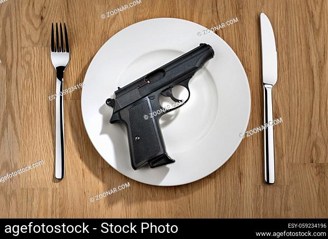 pistol on a white plate with knife and fork