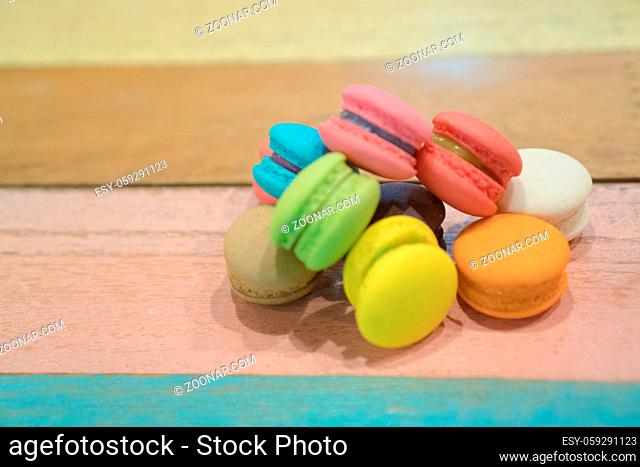 Multicolored macaroons on white wooden background. . Macaron or Macaroon is sweet meringue-based confection