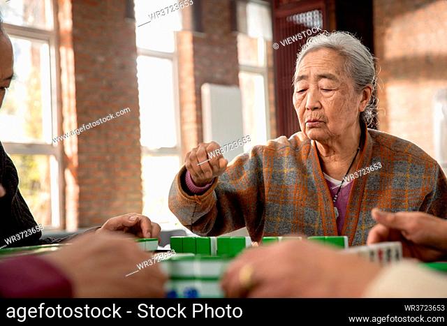 Happy old people playing mahjong