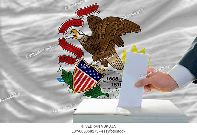 man voting on elections in front of flag US state flag of illino